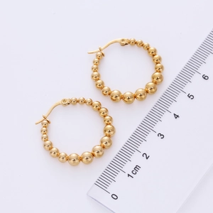 Detail view of 18K gold plated bead hoop earrings showing size measurement with a ruler
