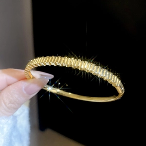 Detail of 18k gold plated bracelet featuring a unique textured and polished split design