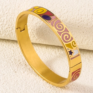 Detail of 18K gold-plated bangle featuring pink, purple, and red enamel star patterns