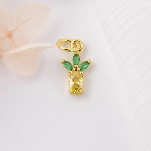 Golden pineapple pendant with yellow and green zircon stones on elegant white background