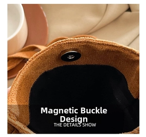Detailed close-up of a silver magnetic snap closure on a brown suede crossbody bag