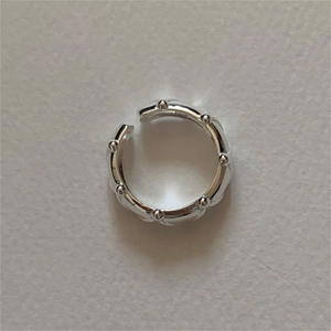 Macro shot of silver wavy ring with bead accents and adjustable open band design