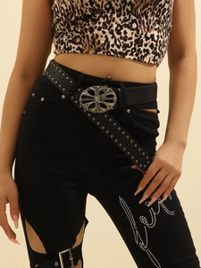 Detail of black leather punk belt with silver cross buckle and metal studs on a model