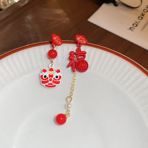 Detail of New Year earrings with red Fu character, lion dance head, and golden ingots