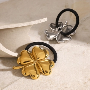 Gold and silver clover metal hair ties on stone display with black elastic bands