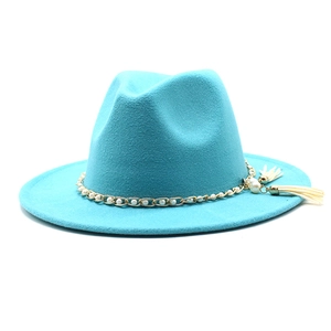Detail of teal fedora hat featuring gold chain with pearls and white tassel pendants