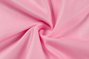 Detailed macro shot of premium pink textured fabric with elegant pleated spiral patterns