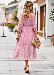 Outdoor street view showing the back profile of this pink floral midi dress with sleeves
