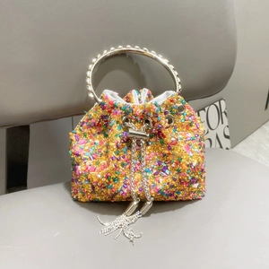 Detail of colorful rhinestone bucket bag with metal ring handle and tassel drawstring