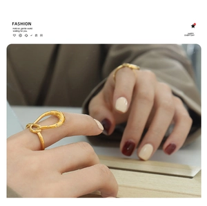 Close-up of gold geometric twisted ring with micro-set zircons on model finger