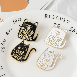 Cartoon enamel cat and dog brooches with dog mom and cat lady text on a ceramic plate
