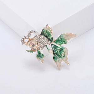 Detailed close-up of goldfish brooch with sparkling crystals and green enamel fins