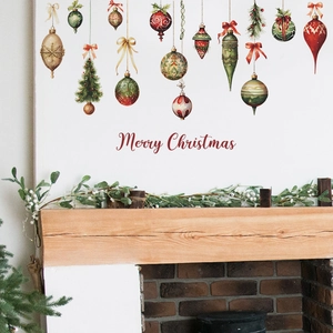 Christmas wall stickers with festive ornaments and trees on a white wall above a fireplace