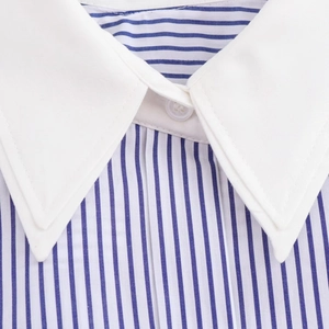 Detail of blue and white striped shirt showing the white collar and single button closure