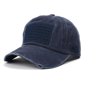 Close-up of distressed navy blue cotton baseball cap with USA embroidery and flag patch detail