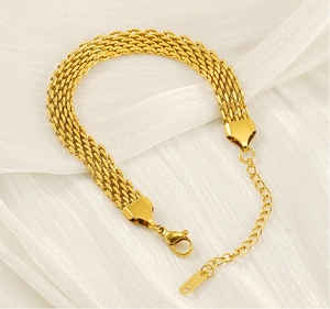 Detail of gold woven mesh bracelet with 18K hallmark on white satin background