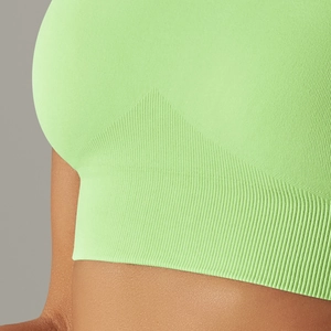 Close-up of seamless knitted texture and ribbed hem on neon green sports bra
