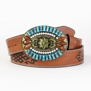 Detail of western cowboy leather belt with ornate turquoise and pearl inlaid buckle