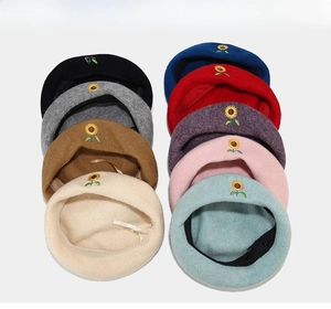 Detailed grid of wool berets in nine colors featuring sunflower embroidery motifs