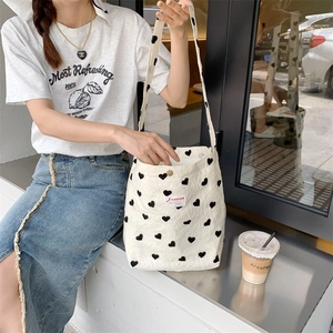 Large off-white canvas tote bag with black heart pattern and woven label detail