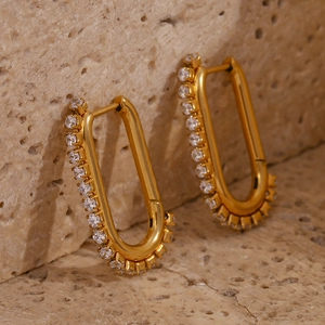 Detail of 18K gold plated U-shaped earrings with sparkling cubic zirconia on stone