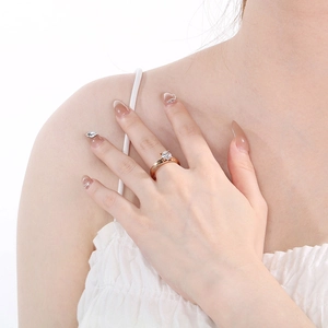 Detail of rose gold plated titanium ring with a single zircon on a woman's hand