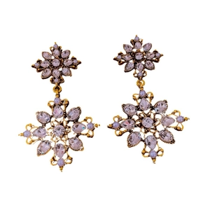 Vintage gold earrings with floral crystal accents and delicate pearls on white background