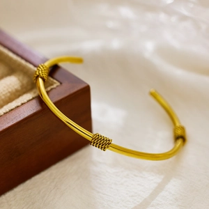 Minimalist adjustable golden twist knot bangle bracelet crafted from polished titanium steel