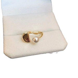 French luxury gold plated ring featuring a pearl and bean charm in a white jewelry box
