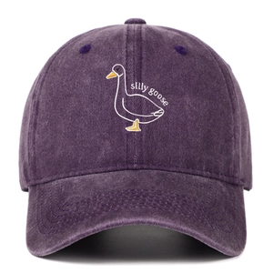 Close-up of silly goose embroidery on washed dark purple cotton baseball cap fabric