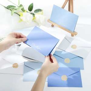 Detail of blue and white Thank You cards with gold foil text and rose wax seal envelopes