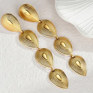 Vintage gold-tone bohemian teardrop tassel earrings in textured stainless steel