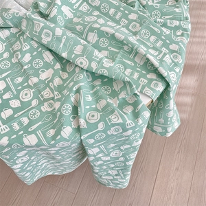 Close-up of mint green linen tablecloth with white hand-drawn kitchen patterns