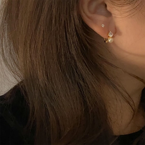 Detail shot of a gold-plated sterling silver earring with a sparkling zircon and pearl
