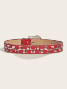 Detailed view of red punk leather belt featuring silver studs and crocodile texture