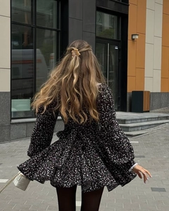 Vue arrière dynamique d'une robe fleurie française avec manches bouffantes et jupe fluide