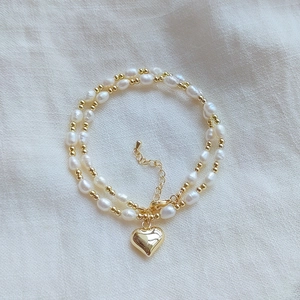 Natural freshwater pearl necklace with gold beads and a polished heart pendant charm