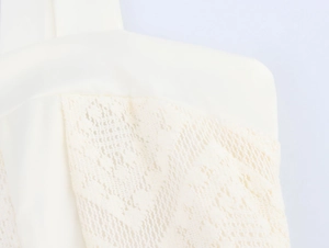 Gros plan sur la dentelle crème élégante et la texture ajourée de la robe française