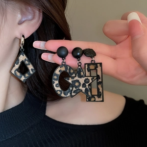 Détail macro de boucles d'oreilles léopard géométriques aux formes et textures variées
