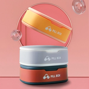 Portable silicone mini pill box in multiple colors shown in a geometric pink studio setting