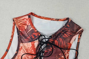 Close-up of retro printed tank top featuring black lace-up neck and fabric texture detail