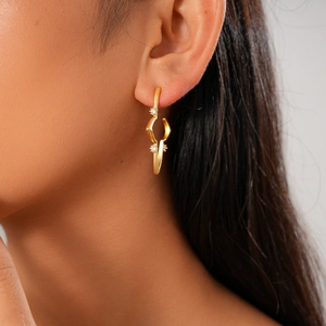 Close-up of 18K gold plated starburst hoop earrings with zircon on a female model