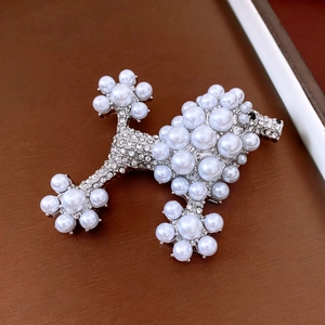 Macro shot of a silver poodle brooch with white pearls and sparkling rhinestones