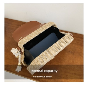 Detail of straw crossbody bag showing internal storage capacity with a smartphone inside
