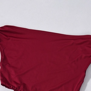 Vue détaillée du tissu en maille rouge foncé avec un éclat doux sur fond texturé