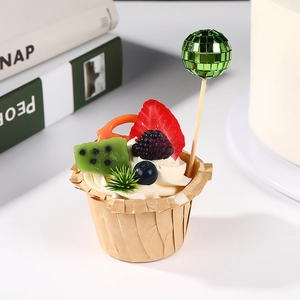 Detail of green disco ball cake toppers with fresh fruit on mini cupcakes for party decor