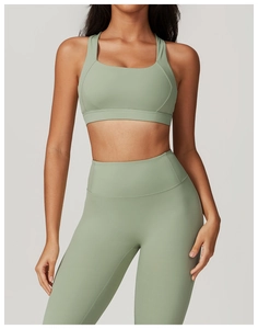 Dettaglio del set da yoga verde salvia con reggiseno vogatore e leggings a compressione