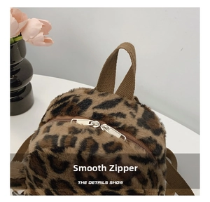 Close-up of leopard plush backpack featuring durable dual metal zippers and a fabric handle