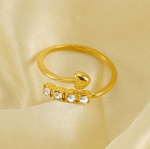 Detail of 18K gold-plated titanium steel ring with heart and four zircons on satin cloth