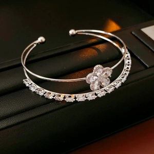 Vue macro du bracelet double couche en argent avec fleur en zircone sur fond de cuir noir